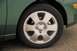 2002 Ford Focus - Close-up of a green car's wheel, showing the silver rim with the Ford emblem and a portion of the fender.