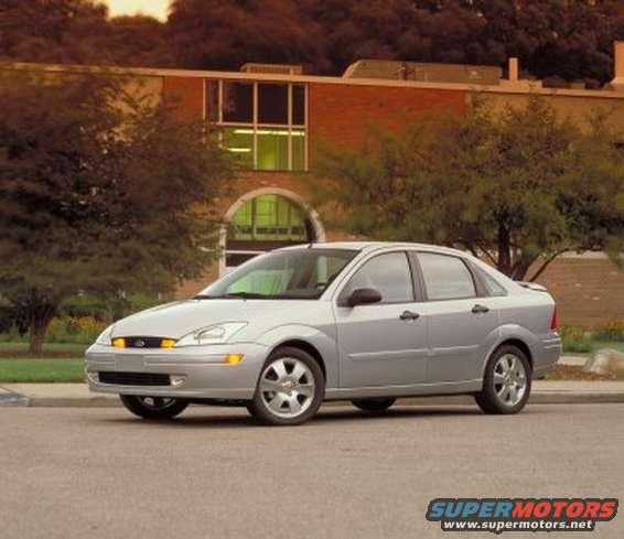 Silver 2002 Ford Focus sedan parked in front of a brick building