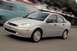 2002 Ford Focus - A silver sedan is captured in motion on a paved road, with a blurred background suggesting movement.