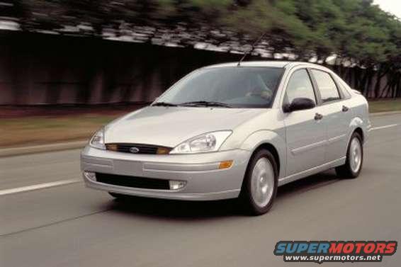 Silver sedan driving on a road, front 3/4 view. The car has a dented front bumper and visible motion blur