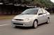 2002 Ford Focus - A silver sedan is captured in motion on a road, showing a front three-quarter perspective with motion blur.
