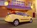 2002 Ford Focus - A yellow 2002 Ford Focus hatchback is parked outside a cafe with a 'Have a Nice Day Cafe' sign.
