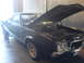 1972 Ford Ranchero - A black 1972 Ford Ranchero sits in a garage with its hood open, revealing the engine compartment.