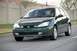 2002 Ford Focus - A green Ford Focus hatchback is shown driving on a road with a driver visible inside.