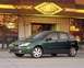 2002 Ford Focus - A green 2002 Ford Focus hatchback is shown from the front three-quarter view in front of a restaurant.