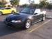 2002 Ford Mustang - Two Ford Mustangs, a convertible and a coupe, parked in a lot.