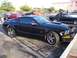 2002 Ford Mustang - A black Ford Mustang GT is parked in a lot, with other vehicles visible in the background.