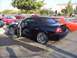2002 Ford Mustang - A black 2002 Ford Mustang convertible is parked with its doors open, custom chrome wheels.