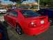 2002 Ford Mustang - Rear view of a red 2002 Ford Mustang GT coupe with custom wheels.