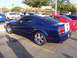 2002 Ford Mustang - A blue Ford Mustang GT with custom wheels and white racing stripes is parked in a lot with other vehicles.