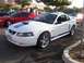 2002 Ford Mustang - A white 2002 Ford Mustang GT is parked in a lot, with a red Mustang and other vehicles visible.