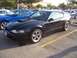 2002 Ford Mustang - Black 2002 Ford Mustang GT parked in a lot with other vehicles.