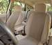 2002 Ford Focus - The interior of a car features cloth seats and an armrest, with greenery visible outside.