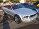 2002 Ford Mustang - A silver convertible Mustang is parked at an outdoor event, with other vehicles visible in the background.