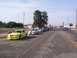 2002 Ford Mustang - A line of Ford Mustangs, including a yellow 2002 model, are parked on the side of a street.