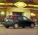 2002 Ford Focus - This 2002 Ford Focus wagon is seen from the side, parked in front of a building with a distinctive yellow and black sign.