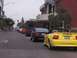 2002 Ford Mustang - A line of Ford Mustangs drives down a street during a parade, with spectators watching from the sidewalk.
