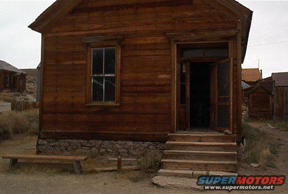 Old wooden building with a porch and steps in a ghost town setting