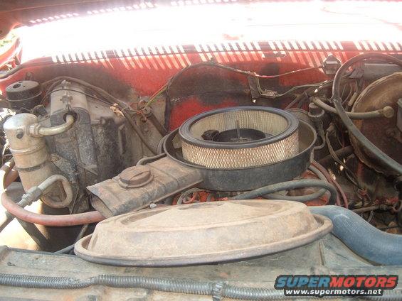 Engine bay with air filter and hoses visible