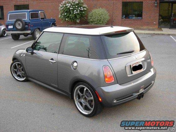 Grey MINI Cooper with white roof, rear 3/4 view, aftermarket wheels