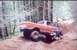 1976 Ford F-100 - Pickup truck driving off-road with another vehicle visible in the background.