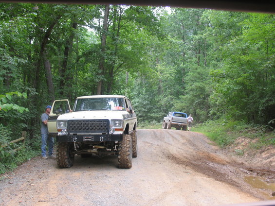 White Ford Bronco with lifted suspension on a dirt road