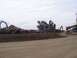 1994 Ford F-150 - Scrap metal yard with heavy machinery and stacked vehicles under a cloudy sky.