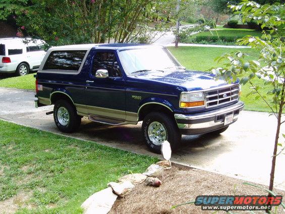 1996 Ford Bronco parked on driveway with white SUV in background