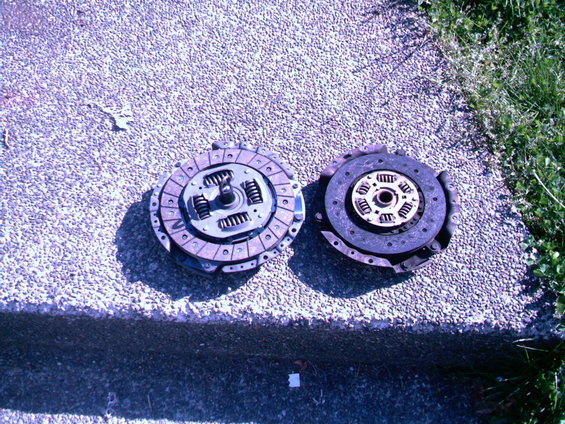 Two clutch assemblies, one with springs visible, resting on a concrete surface