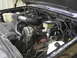 1990 Chevrolet Suburban - The engine bay of a 1990 Chevrolet Suburban is captured in this detailed photograph, highlighting various components.