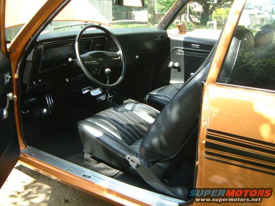 1973 Chevrolet Nova interior, showing black vinyl seats, dashboard, steering wheel, and door panel