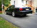 2003 Mercury Marauder - Rear view of a black 2003 Mercury Marauder parked on a paved driveway next to a house.