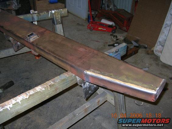 Custom steel bumper section on sawhorses, showing welds and a square cutout