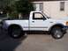 1994 Ford Ranger - A white Ford Ranger pickup truck is shown from the side, parked in front of a house.