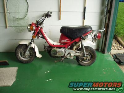Red scooter with black seat parked inside a garage