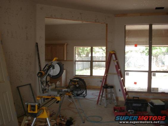 Interior construction scene with miter saw, ladder, and tools
