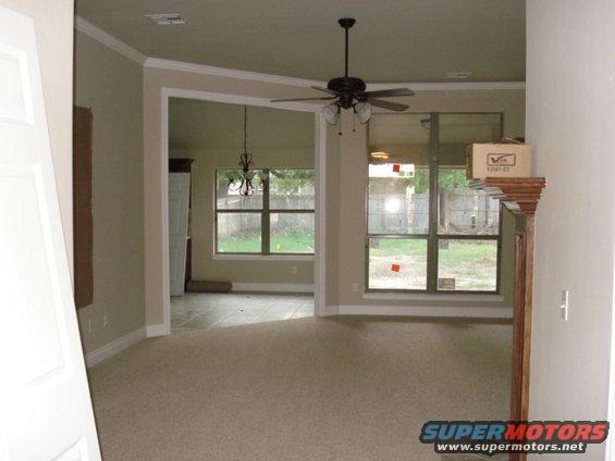 Interior of a house with carpet and large windows overlooking a yard
