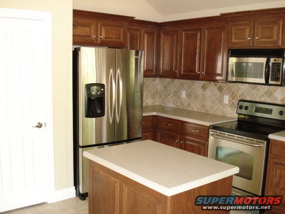 Kitchen with stainless steel refrigerator, wooden cabinets, and a stove