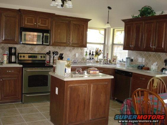 Kitchen with dark wood cabinets, stainless steel appliances, and an island