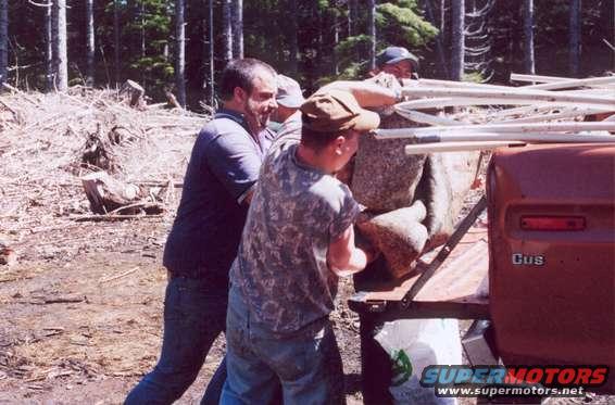 Red truck bed with people loading rocks