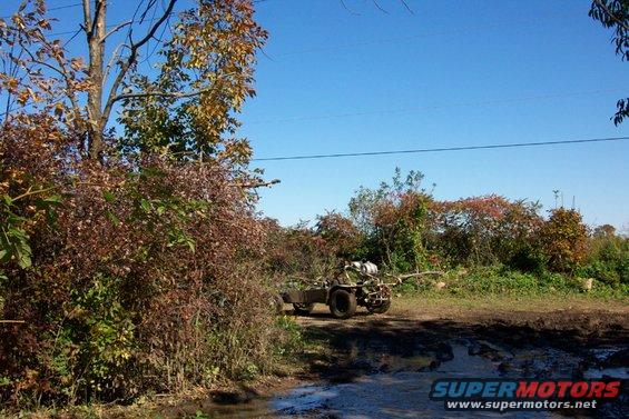 All-terrain vehicle towing a trailer on a muddy path