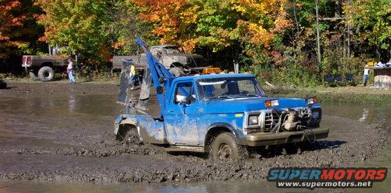 Blue tow truck stuck in mud, 1979 Ford F-Series truck body style