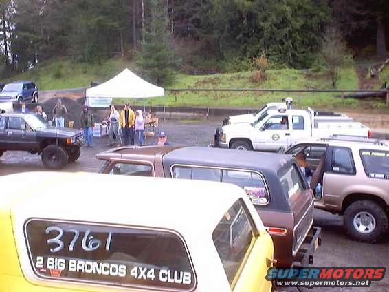 Yellow vehicle with '2 BIG BRONCOS 4X4 CLUB' text, parked near other trucks and SUVs