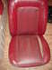 1979 Ford Bronco - This is a red leather car seat, likely from an older vehicle, showing signs of wear.
