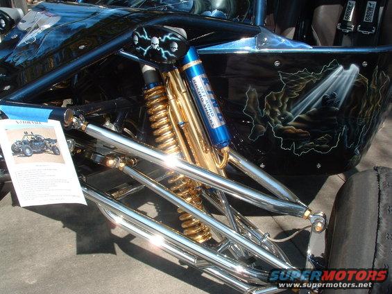 Custom buggy front suspension with gold coilover shocks and blue Koni racing shocks. "FOR SALE" sign visible