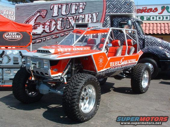 Orange off-road buggy with roll cage and 'Tuff Country' graphics