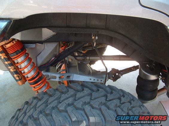 Close-up of off-road suspension with orange King shocks and air springs