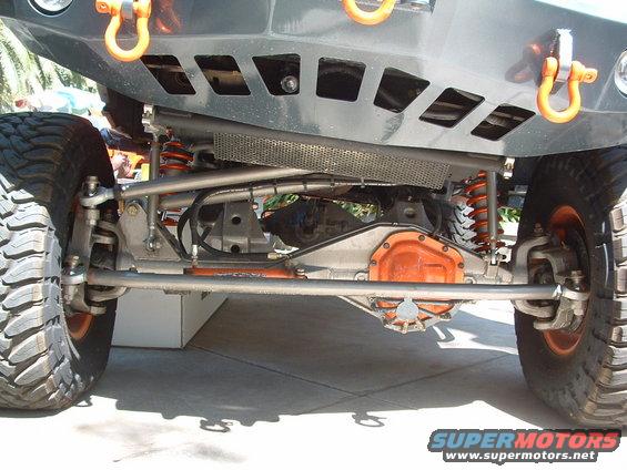 Off-road vehicle front suspension and differential with orange accents and large tires