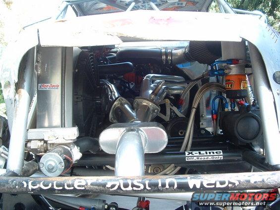 Engine bay with custom exhaust, air intake, and radiator. Off-road sticker visible