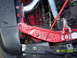 1990 Ford Mustang - Close-up view of the engine bay, showing red structural components and a chrome intake pipe.